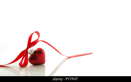 Rotes Herz für Weihnachten mit einem Bogen von einem roten Band auf White Ribbon isoliert Stockfoto