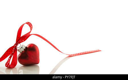 Rotes Herz für Weihnachten mit einem Bogen von einem roten Band auf White Ribbon isoliert Stockfoto