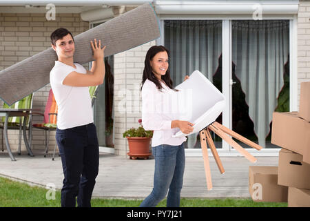 Seitenansicht eines lächelnden jungen Paar Umzug in Ihr neues Haus Stockfoto