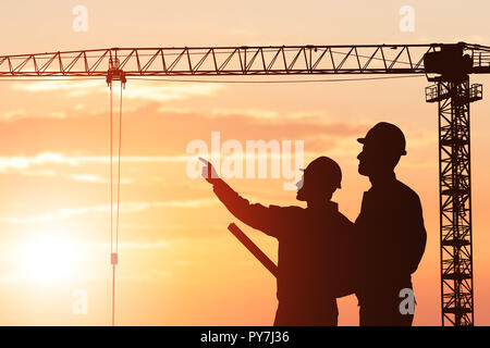 Silhouette eines Architekten zeigen etwas an seinen Partner auf der Baustelle Stockfoto