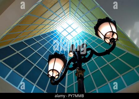 Abstrakte Perspektive der vertikalen Lobby Decke mit Oberlicht, vintage Lampe und starke Geometrie und Symmetrie und dramatische Farben als Hintergrund Stockfoto