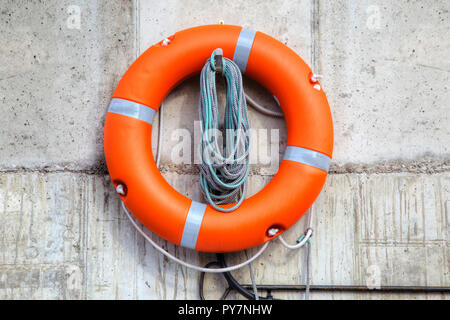 Rettung auf dem Wasser. Rettungsring auf dem Pier an der Wand Stockfoto