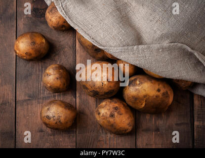 Frische organische Kartoffeln in sackleinen Sack auf Holz- Hintergrund Stockfoto