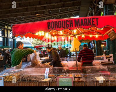 Borough Market Nüsse Nusssorten produzieren Stand mit maßgeschneiderten Nüssen und getrockneten Früchten usw. beleuchtet in der Abenddämmerung Southwark London UK Stockfoto