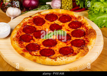 Italienische Pizza Salami mit Basilikum Stockfoto