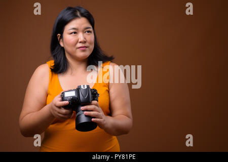 Schöne Übergewicht asiatische Frau Fotograf Denken und Planen Stockfoto