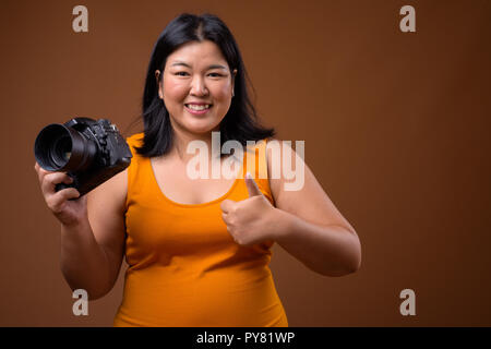 Schöne Übergewicht asiatische Frau Fotograf lächelnd und Daumen hoch Stockfoto