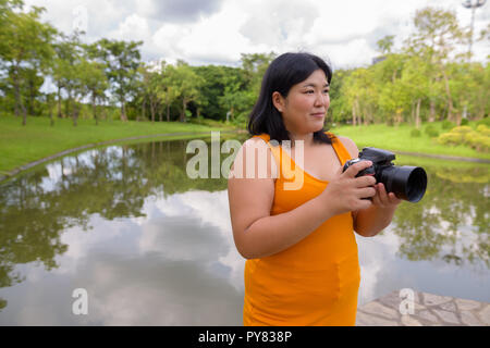 Schöne Übergewicht asiatische Frau Fotograf im Park Stockfoto