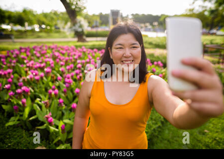 Schöne Übergewicht asiatische Frau unter selfie in Park Stockfoto