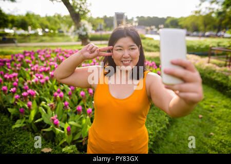 Schöne Übergewicht asiatische Frau unter selfie in Park Stockfoto