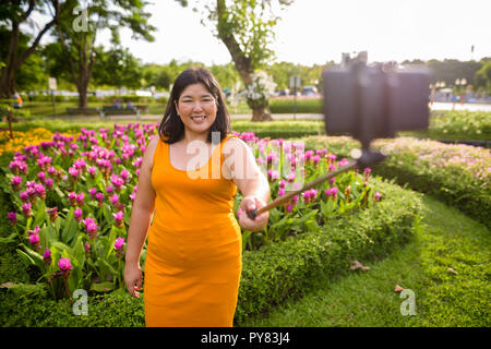 Asiatische Frau unter selfie mit Handy befestigen Stick im Park zu selfie Stockfoto
