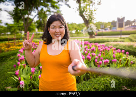 Asiatische Frau unter selfie mit Handy befestigen Stick im Park zu selfie Stockfoto