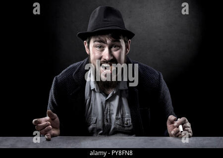 Porträt einer frechen bärtigen Mann in einen Hut mit einer Zigarre im Mund Stockfoto