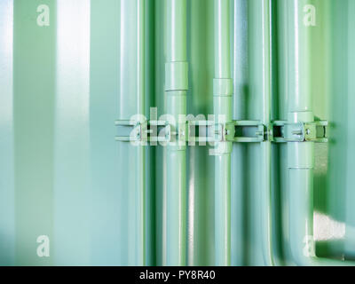 Grüne Pipeline auf Green Shipping Container Wand. Minimalistischen Farben dekoriert. Stockfoto