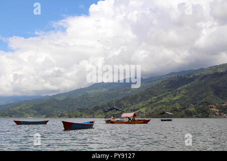 Boote um Phewa-see und Hügeln in Pokhara, ein beliebtes Touristenziel. In Nepal, August 2018. Stockfoto