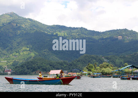 Boote um Phewa-see und Hügeln in Pokhara, ein beliebtes Touristenziel. In Nepal, August 2018. Stockfoto