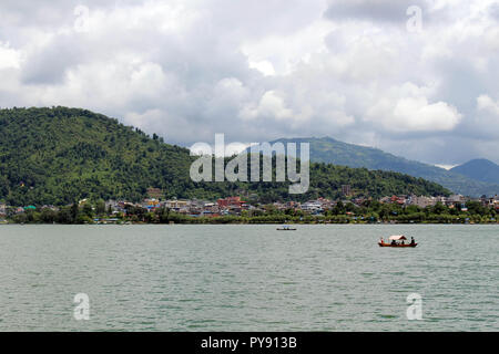 Boote um Phewa-see und Hügeln in Pokhara, ein beliebtes Touristenziel. In Nepal, August 2018. Stockfoto