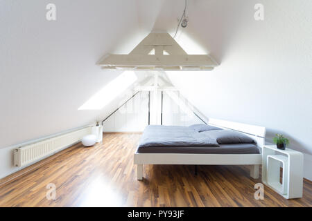 Weitwinkelaufnahme der Moderne, helle, puristischen Dachgeschoss Schlafzimmer mit Doppelbett und grauem Deckel Stockfoto