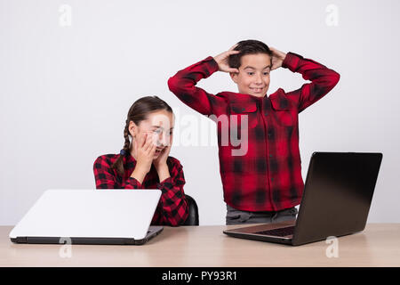 Überrascht Kinder in der Klasse auf einem Computer Stockfoto
