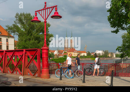 Brücke Breslau, polnischen Jugendlichen schieben Sie ihre Räder über die Rote Brücke (Most Piaskowy) mit Blick auf die Dominsel in der Ferne, Breslau. Stockfoto