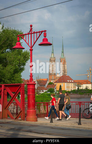 Wroclaw Brücke, polnischen Jugendlichen zu Fuß über die Rote Brücke (Most Piaskowy) im Zentrum von Breslau mit Blick auf die Dominsel in der Ferne. Stockfoto