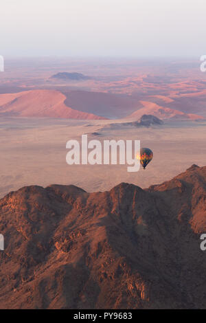 Namibia Travel - Heißluftballon bei Sonnenaufgang über den Sanddünen der Namib-Wüste - Beispiel für Adventure Travel, Namibia Afrika Stockfoto