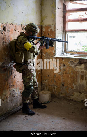 Militärischen mann Sniper mit Sturmgewehr durch die Fenster in alten, verlassenen Gebäude Stockfoto