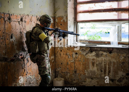 Militärischen mann Sniper mit Sturmgewehr durch die Fenster in alten, verlassenen Gebäude Stockfoto