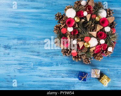 Chistmas Tür Dekoration mit kleinen Geschenkboxen auf Blau Holz- Hintergrund. Gruß Symbol. Stockfoto