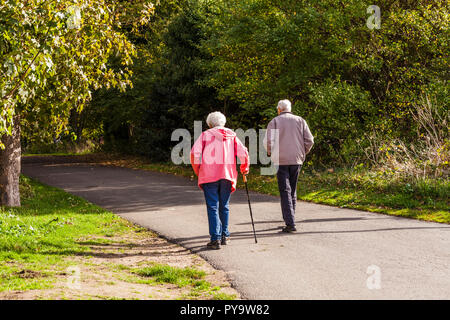 Ein älteres Ehepaar ein Spaziergang entlang einem Baum weg Teddington Lock, London, England, UK gefüttert Stockfoto