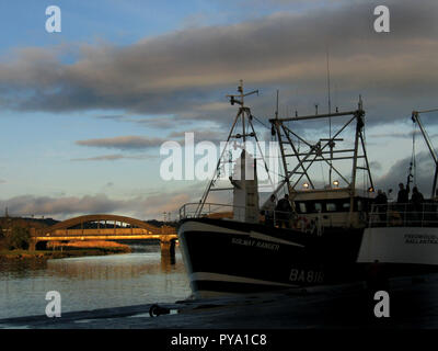 Das Abendlicht leuchtet auf der Dee Bridge in Kirkcudbright Harbour, Dumfries und Galloway, Schottland, wo Jakobsboote der Fischerflotte der Stadt anliegen Stockfoto