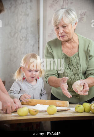 Eine Großmutter und Enkelin machen kleine Torten Stockfoto