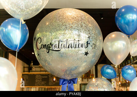 Luftballons mit Wort herzlichen Glückwunsch zu Ballon Dekoration im Restaurant. Stockfoto