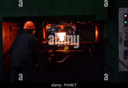 Industrielle Arbeiter in der Fabrik schweißen Nahaufnahme. Heiße Eisen in den weiterverarbeitenden Betrieben, die ein Arbeitnehmer statt. Das Schmelzen des Metalls in der Gießerei. Schwere schmieden steelmaki Stockfoto