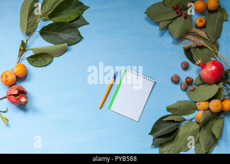 Herbst Früchte, Nüsse, Granatapfel auf blauem Hintergrund Stockfoto