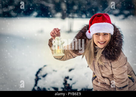 Schöne Mädchen auf Winter Forest mit Weihnachten Laterne Stockfoto