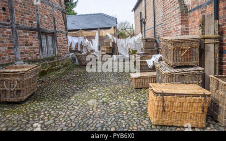 Altmodische wasch Körben und Wäsche trocknen auf eine Linie in einer gepflasterten Hof. Stockfoto