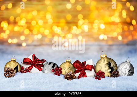 Cryptocurrency Weihnachten Hintergrund crypto Münze Weihnachtskugel Kugeln und Geschenke im Schnee vor der warmen Lichter Schnee Textur bokeh Stockfoto