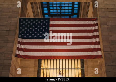 New York, USA - 28. Mai 2018: Große amerikanische Flagge im Grand Central Terminal, dem weltbekannten Wahrzeichen und Verkehrsknotenpunkt in Midtown Manhattan, Stockfoto