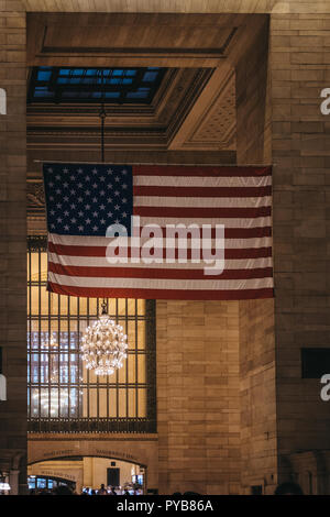 New York, USA - 28. Mai 2018: Große amerikanische Flagge im Grand Central Terminal, dem weltbekannten Wahrzeichen und Verkehrsknotenpunkt in Midtown Manhattan, Stockfoto