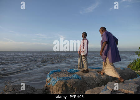 Naria, Shariatpur, Bangladesch. 16 Aug, 2018. Md Nasir Hawladar (links) und sein älterer Bruder Md Fayzal Haque Hawladar bei der Bank von Padma Fluss, wo Sie Ihr Haus und Land zu den Fluss verloren. Auswirkungen des Klimawandels sind sehr visuell in einem Land wie Bangladesch. Im Jahr 2018, ein schneller Fluss erosion Geschehen rund um die Bereiche neben dem Padma River. Viele Menschen verloren ihre Häuser, Grundstücke und die Art zu Leben. Dieser schnellen Fluss erosion machte viele Klimaflüchtlingen. Credit: Ziaul Haque Oisharjh/SOPA Images/ZUMA Draht/Alamy leben Nachrichten Stockfoto