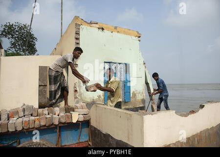 Naria, Shariatpur, Bangladesch. 14 Sep, 2018. Männer gesehen die Extraktion der Ziegel für Geld aus einem Haus, das sich durch den Fluss untergraben werden. Auswirkungen des Klimawandels sind sehr visuell in einem Land wie Bangladesch. Im Jahr 2018, ein schneller Fluss erosion Geschehen rund um die Bereiche neben dem Padma River. Viele Menschen verloren ihre Häuser, Grundstücke und die Art zu Leben. Dieser schnellen Fluss erosion machte viele Klimaflüchtlingen. Credit: Ziaul Haque Oisharjh/SOPA Images/ZUMA Draht/Alamy leben Nachrichten Stockfoto