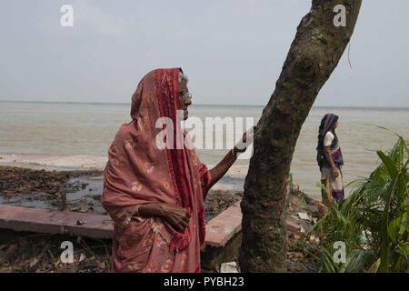 Naria, Shariatpur, Bangladesch. 14 Sep, 2018. Aysha (links) gesehen stehen neben die Reste ihres nach Hause nach ausgehöhlt wird. Die Auswirkungen des Klimawandels sind sehr visuell in einem Land wie Bangladesch. Im Jahr 2018, ein schneller Fluss erosion Geschehen rund um die Bereiche neben dem Padma River. Viele Menschen verloren ihre Häuser, Grundstücke und die Art zu Leben. Dieser schnellen Fluss erosion machte viele Klimaflüchtlingen. Credit: Ziaul Haque Oisharjh/SOPA Images/ZUMA Draht/Alamy leben Nachrichten Stockfoto