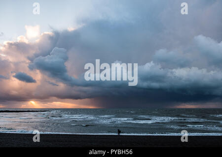 Aberystwyth Wales UK, 26/10/2018 UK Wetter: Bei Sonnenuntergang, dramatisch dunklen Sturmwolken broodingly über die Cardigan Bay aus Aberystwyth, bedrohlich starken Regen- und Hagelschauern Duschen am Ende eines Tages des beißend kalten Nordwind den ersten Geschmack von Winter zu viel von Großbritannien. Photo credit Keith Morris/Alamy leben Nachrichten Stockfoto