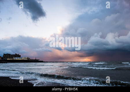 Aberystwyth Wales UK, 26/10/2018 UK Wetter: Bei Sonnenuntergang, dramatisch dunklen Sturmwolken broodingly über die Cardigan Bay aus Aberystwyth, bedrohlich starken Regen- und Hagelschauern Duschen am Ende eines Tages des beißend kalten Nordwind den ersten Geschmack von Winter zu viel von Großbritannien. Photo credit Keith Morris/Alamy leben Nachrichten Stockfoto