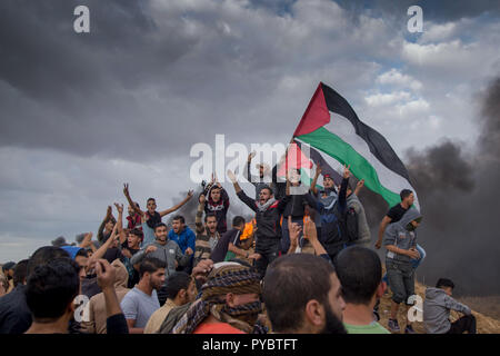 Gaza, Palästina. 22 Okt, 2018. Die palästinensische Demonstranten gesehen Holding palästinensischen Flaggen während des Protestes. Hunderte von palästinensischen protestierten über die israelische Blockade bei den wöchentlichen Protest von März zurück. Credit: Yousef Masoud/SOPA Images/ZUMA Draht/Alamy leben Nachrichten Stockfoto