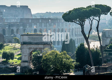 Am frühen Morgen Blick über das Forum Romanum zum Bogen des Titus, mit dem Kolosseum im Hintergrund, Rom, Italien. Stockfoto