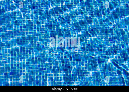 Spiegelnde Wasseroberfläche ein Pool, mit blauen Mosaikfliesen, die einen verschwommenen Eindruck. Stockfoto