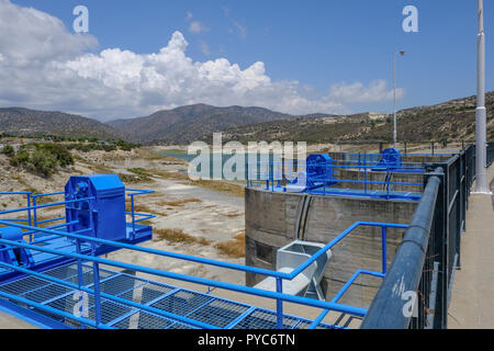 Germasogeia Damm auf einem strahlend blauen Himmel Tag Anfang Sommer. Zeigt die blaue Mechanismus für den Überlauf in der foreghround. Stockfoto