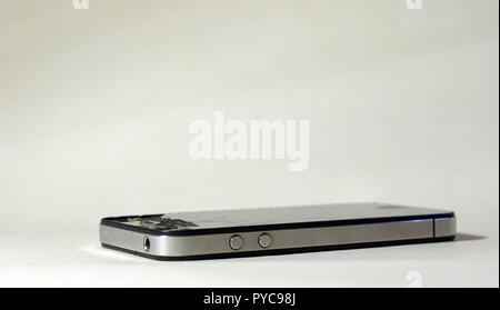 Gebrochene Handy auf einem weißen Hintergrund. Risse im Glas bei der Minianwendung Stockfoto